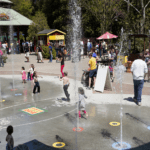 A crowded area of the zoo featuring Splash Fountain and the carousel.