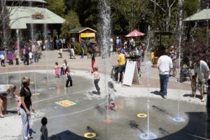 A crowded area of the zoo featuring Splash Fountain and the carousel.