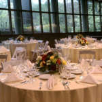 An event space set up with tables, linens and chairs