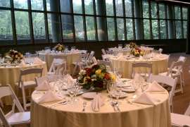 An event space set up with tables, linens and chairs