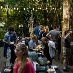 A large group gathers on the gorilla deck for a festive party with food and drink.