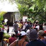 A large group of guests wait outside a large white tent in the Zoo.