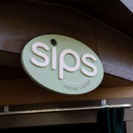 A sign reading "Sips" for the coffee restaurant offering in Zoo Atlanta's Flamingo Plaza.